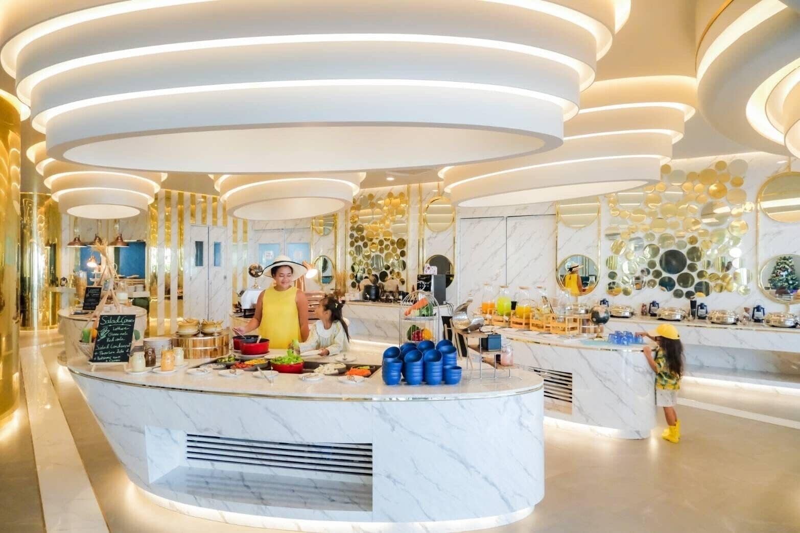 Un'area colazione moderna e luminosa, con banconi in marmo, un buffet e un soffitto decorativo.