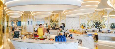 A modern, well-lit breakfast area with marble countertops, a buffet setup, and a decorative ceiling.