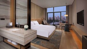 A modern hotel room with a large bed, a bathroom with a marble vanity, a city view, and a flat-screen TV. - Ramada by Wyndham Hengyang Zhengxiang (Hengyang)