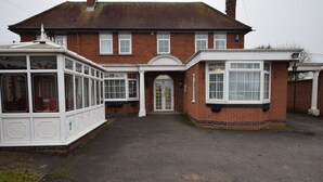 A two-story brick house with a front entrance, a conservatory, and a garage. - Watling Inn (Nuneaton)