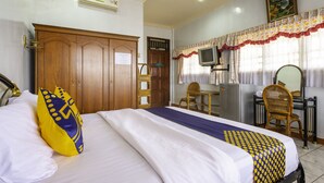A hotel room with a bed, a desk, a chair, a television, and a wardrobe. - SPOT ON 1896 Hotel Mahkota Pantai (Pelabuhan Ratu)