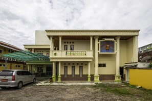 A hotel with a classic architectural style, featuring a central entrance with columns, a balcony, and a sign that reads "Welcome to the Hotel." - SPOT ON 1896 Hotel Mahkota Pantai (Pelabuhan Ratu)