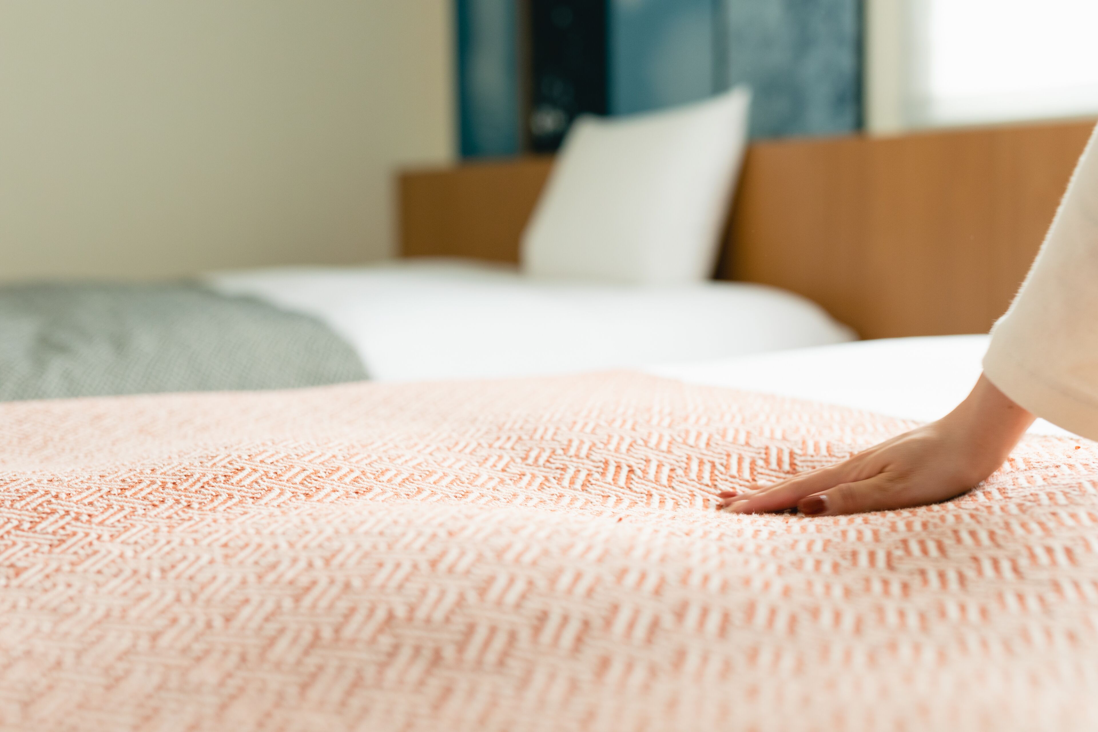 Un letto con una coperta fantasia e una testiera in legno.