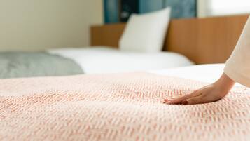 A bed with a patterned blanket and a wooden headboard.