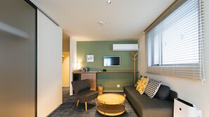A modern living room with a sofa, armchair, and round coffee table.