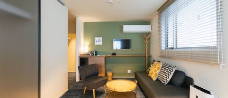 A modern living room with a sofa, armchair, and round coffee table.