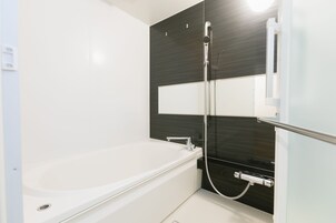 Bañera con ducha, secador de pelo, pantuflas