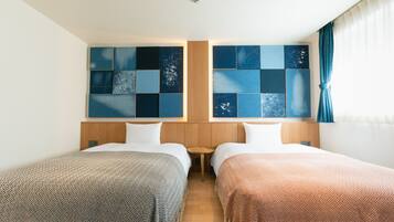 A hotel room with two beds, a wooden headboard, a small table, and a wall with a geometric pattern.