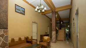 A spacious lobby with a sofa set, a glass-top coffee table, and a chandelier. - OYO 2181 Hotel Grand Yuda (Tenggarong)