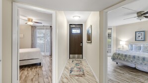 A hallway with a bed, a door, and a ceiling fan. - Sea Gull #107: Beachfront 2 Bedroom 2 Bathroom With Spectacular Views and 24 Hour Management (Port Aransas)