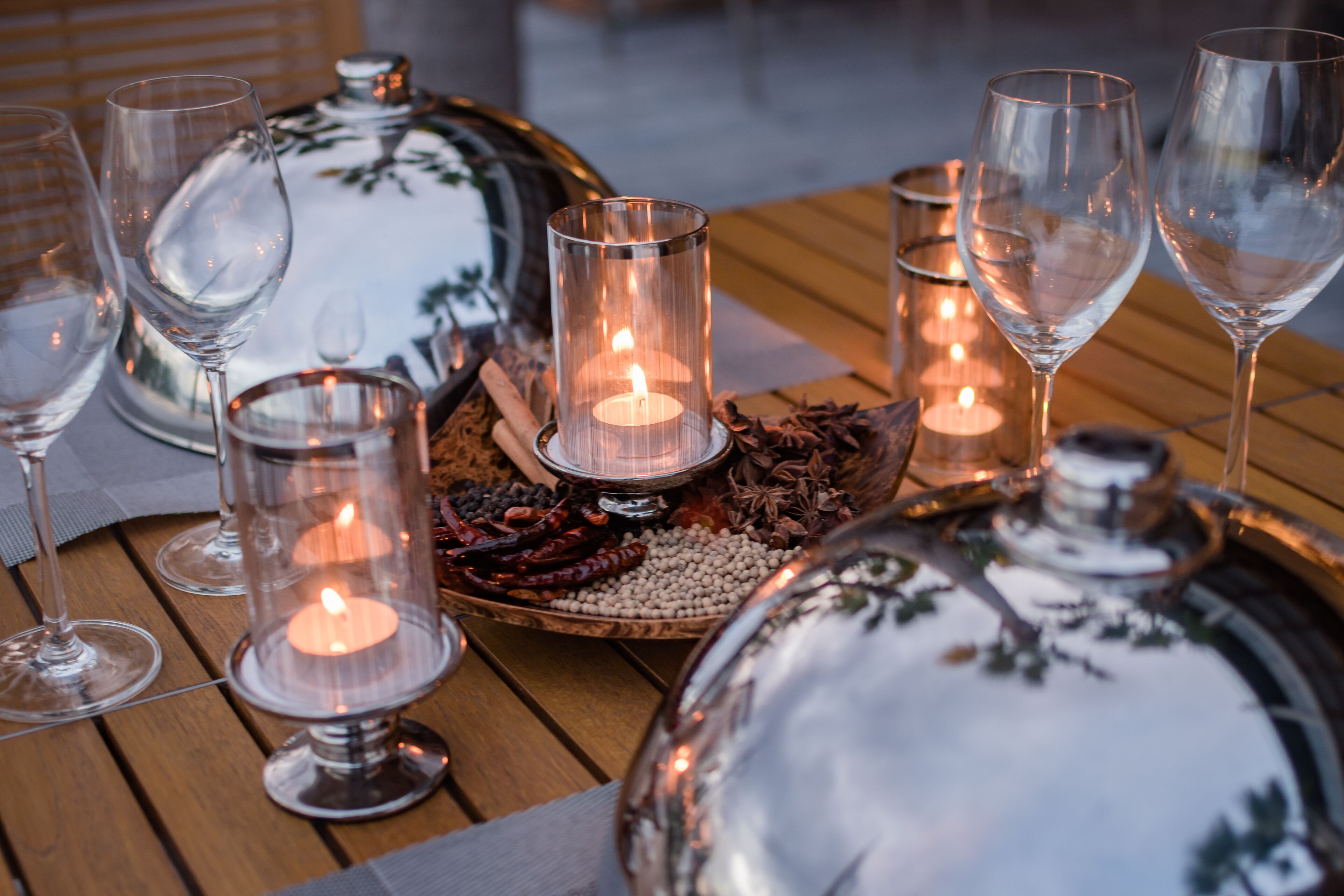 A table set with wine glasses, candles, and decorative items.
