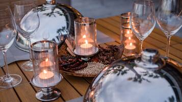 A table set with wine glasses, candles, and decorative items.