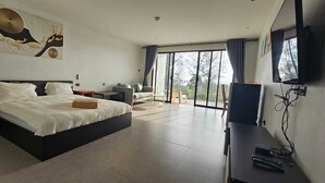 A modern bedroom with a large bed, a TV, and a balcony with a view. - Aranya Resort Koh Lanta (Ko Lanta)
