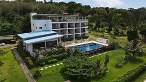 A modern hotel with a pool, surrounded by lush greenery and a forested hillside. - Aranya Resort Koh Lanta (Ko Lanta)