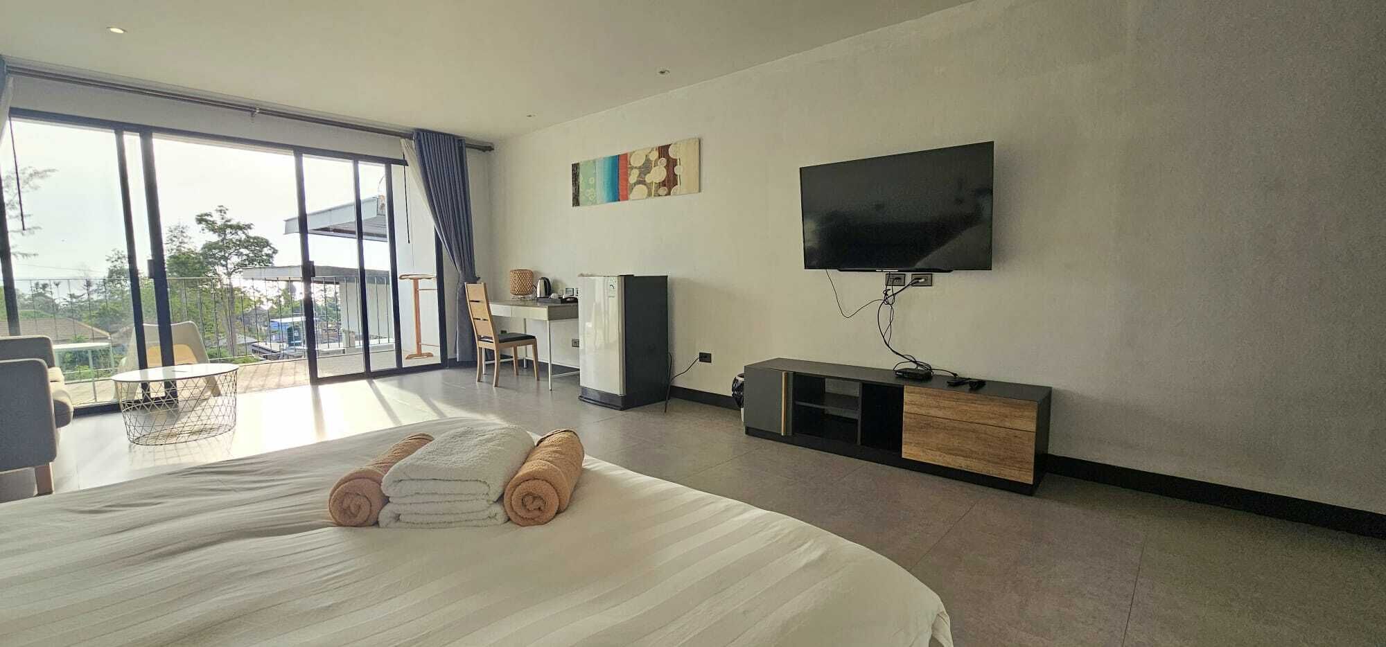 Een moderne hotelkamer met een groot bed, een flatscreen-tv, een bureau en een stoel.
