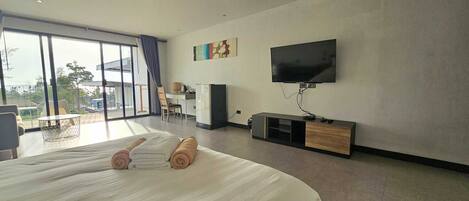 Een moderne hotelkamer met een groot bed, een flatscreen-tv, een bureau en een stoel.
