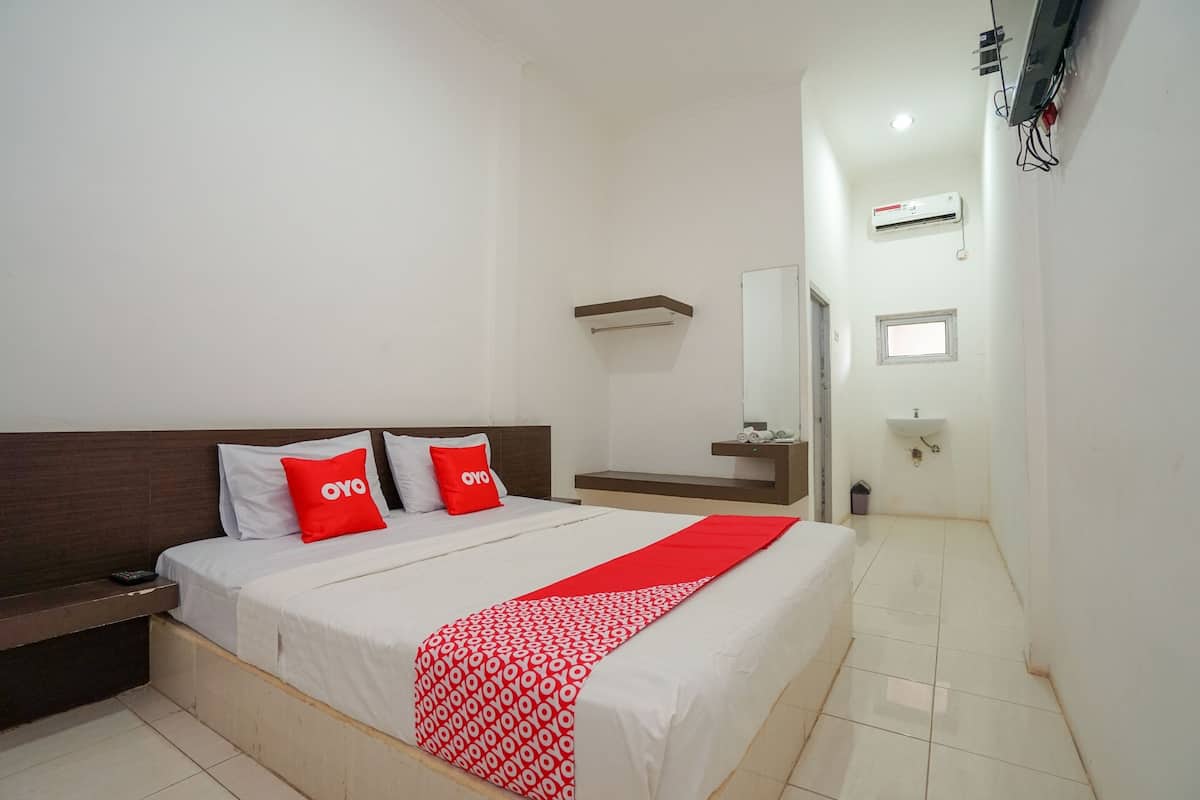 Une chambre d’hôtel comprenant un lit, une table de chevet, un miroir, une fenêtre et une salle de bain avec un lavabo et un miroir.