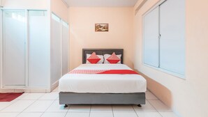 A bedroom with a bed, a wardrobe, and a window. - Hotel O J&b Room Pramuka (Jakarta)