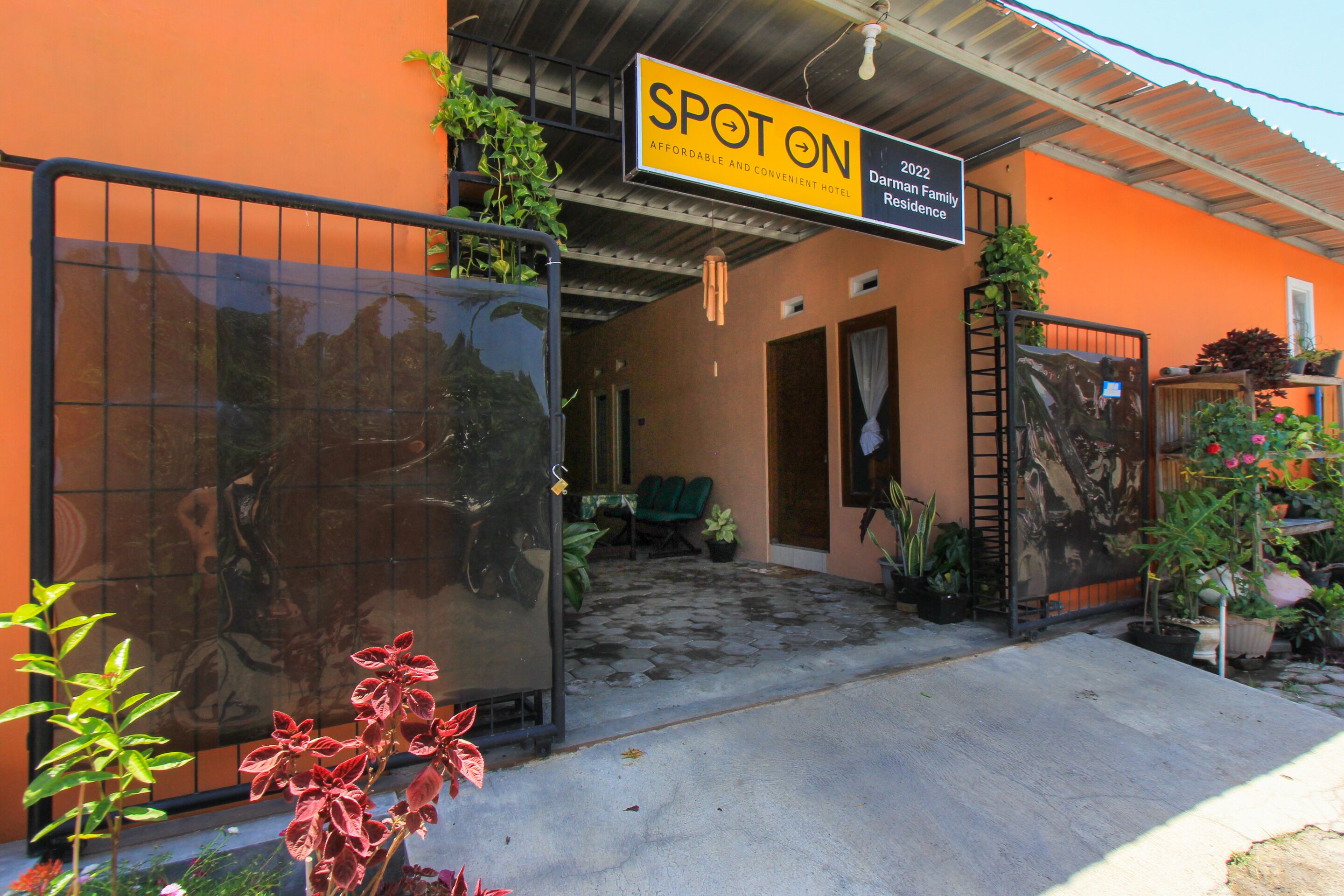 A hotel entrance with a sign reading "SPOT ON AFFORDABLE AND CONVENIENT HOTEL" and "Darwin Family Residence 2022".