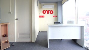 A room with a desk, a door, an air conditioning unit, and a window. - OYO 689 Baan Yuyuen (Pathum Thani)