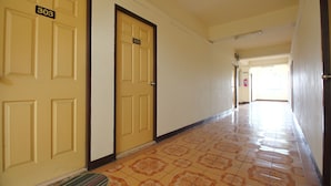 A hotel hallway with doors numbered 303 and 302, leading to rooms. - OYO 689 Baan Yuyuen (Pathum Thani)