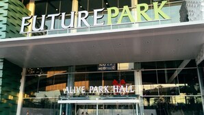 Das Gebäude von außen, mit einem Schild, auf dem 'FUTURE PARK' und 'ALIVE PARK HALL' steht.