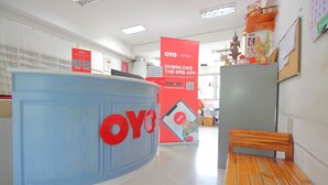 Ein Empfangsbereich mit einer blauen Theke und einem roten Schild mit dem Schriftzug OYO Hotels.