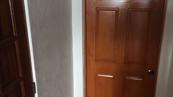 A wooden door with a simple design, a small peephole, and a door handle.