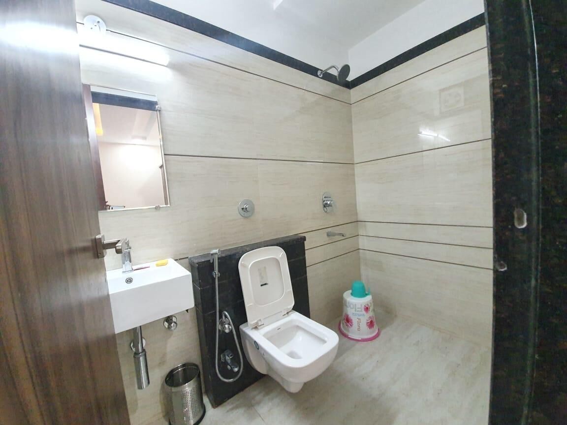 A bathroom with a toilet, sink, and shower.
