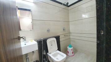 A bathroom with a toilet, sink, and shower.