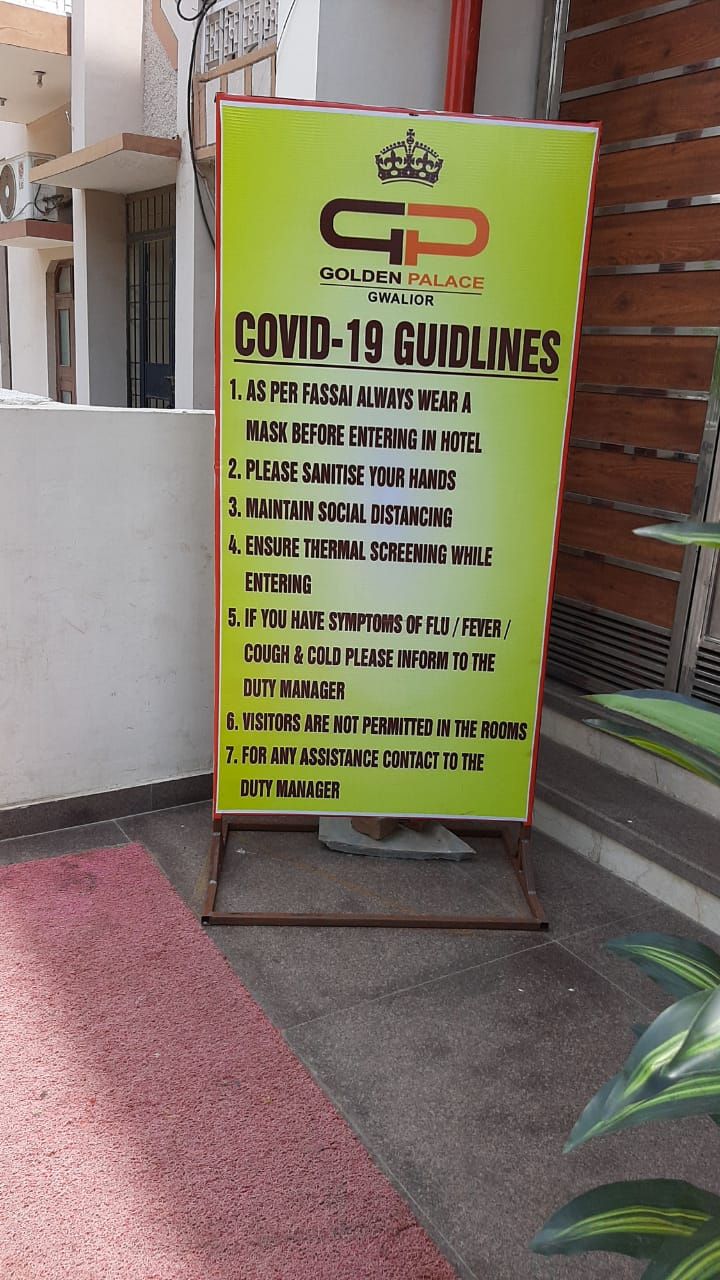 Een bord met COVID-19 richtlijnen bij de ingang van Golden Palace Gwalior.