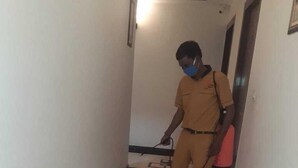 Una persona in divisa pulisce un corridoio con un aspirapolvere.