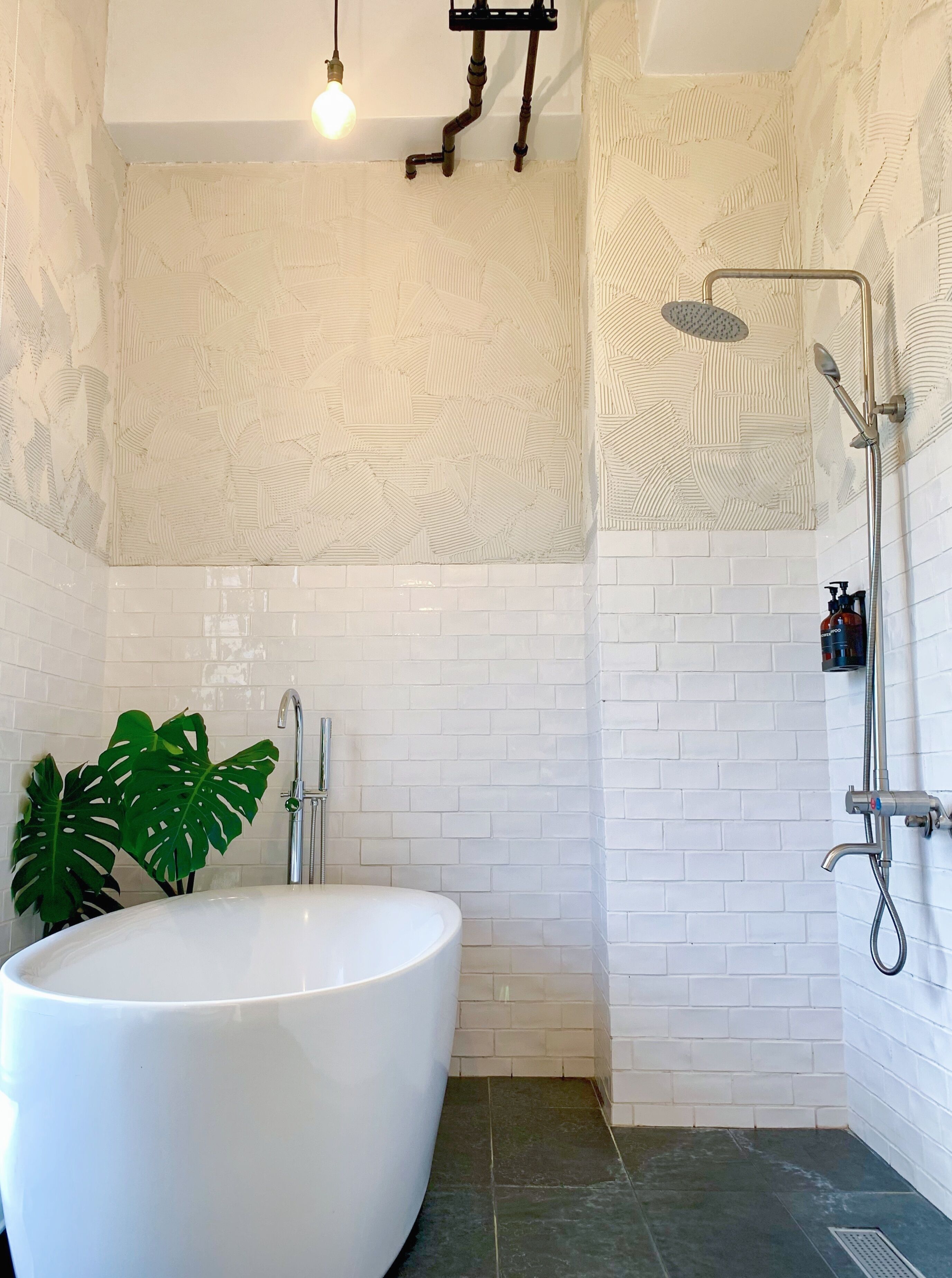 A bathroom with a freestanding bathtub, a shower, and a sink.