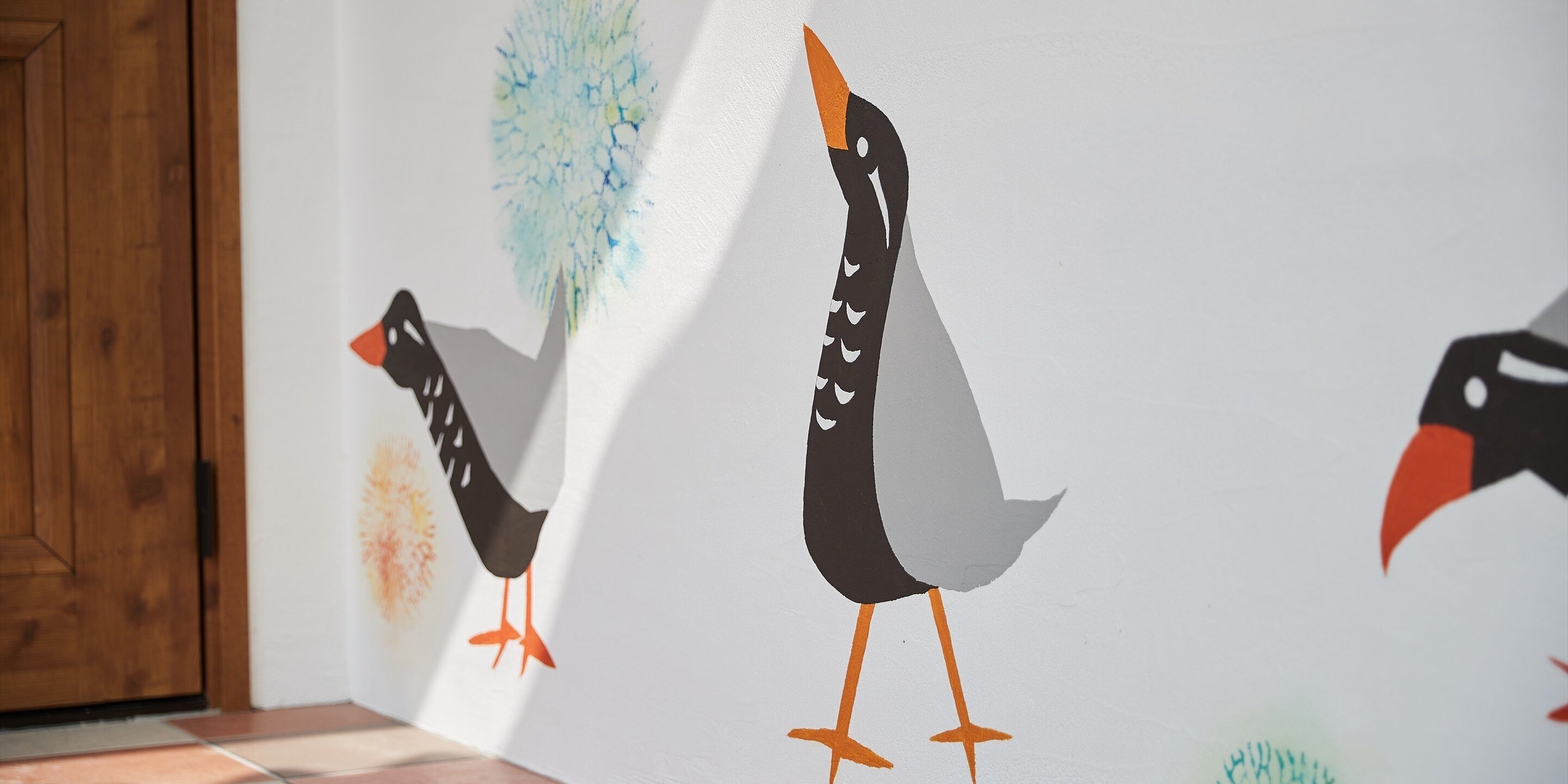 Pared con tres ilustraciones de aves.