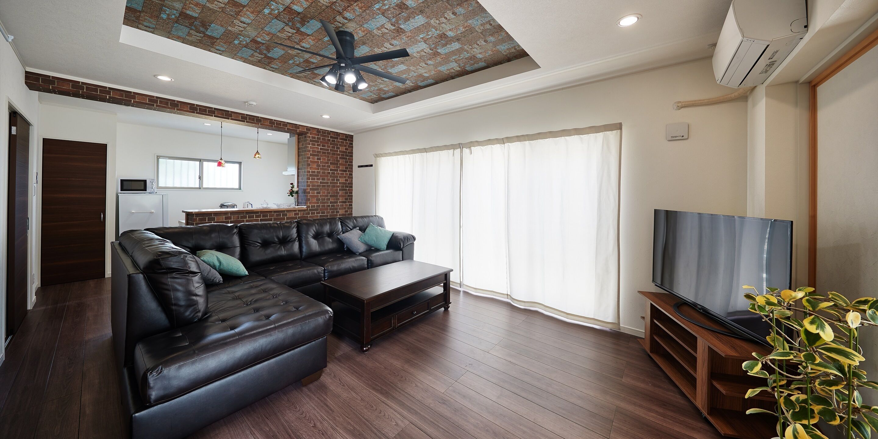 A modern living room with a sectional sofa, a coffee table, and a TV on a wooden stand.