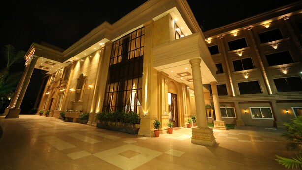 A grand hotel entrance with a spacious lobby, large columns, and potted plants. - Hotel Prince Viraj (Jabalpur)