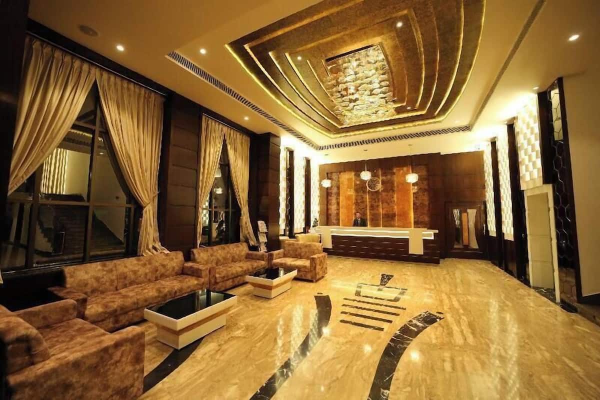 A spacious lobby with a modern sofa set, a reception desk, and a stone accent wall.