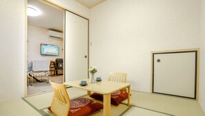 Une pièce de style japonais traditionnel, avec un sol recouvert de tatamis, une table basse et des paravents en papier de riz (shoji).