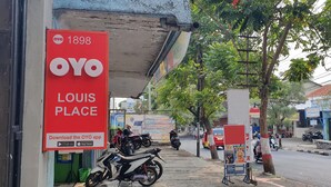 En butik med et iøjnefaldende rødt skilt, der reklamerer for OYO og Louis Place.