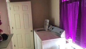 A laundry room with a washing machine and dryer, a sink, and a door. - Convenient and clean studio near the beach and Newport. (Middletown)