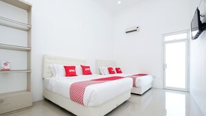 Una habitación de hotel moderna con dos camas, ropa de cama blanca, detalles en rojo, un televisor de pantalla plana y un ventanal grande.