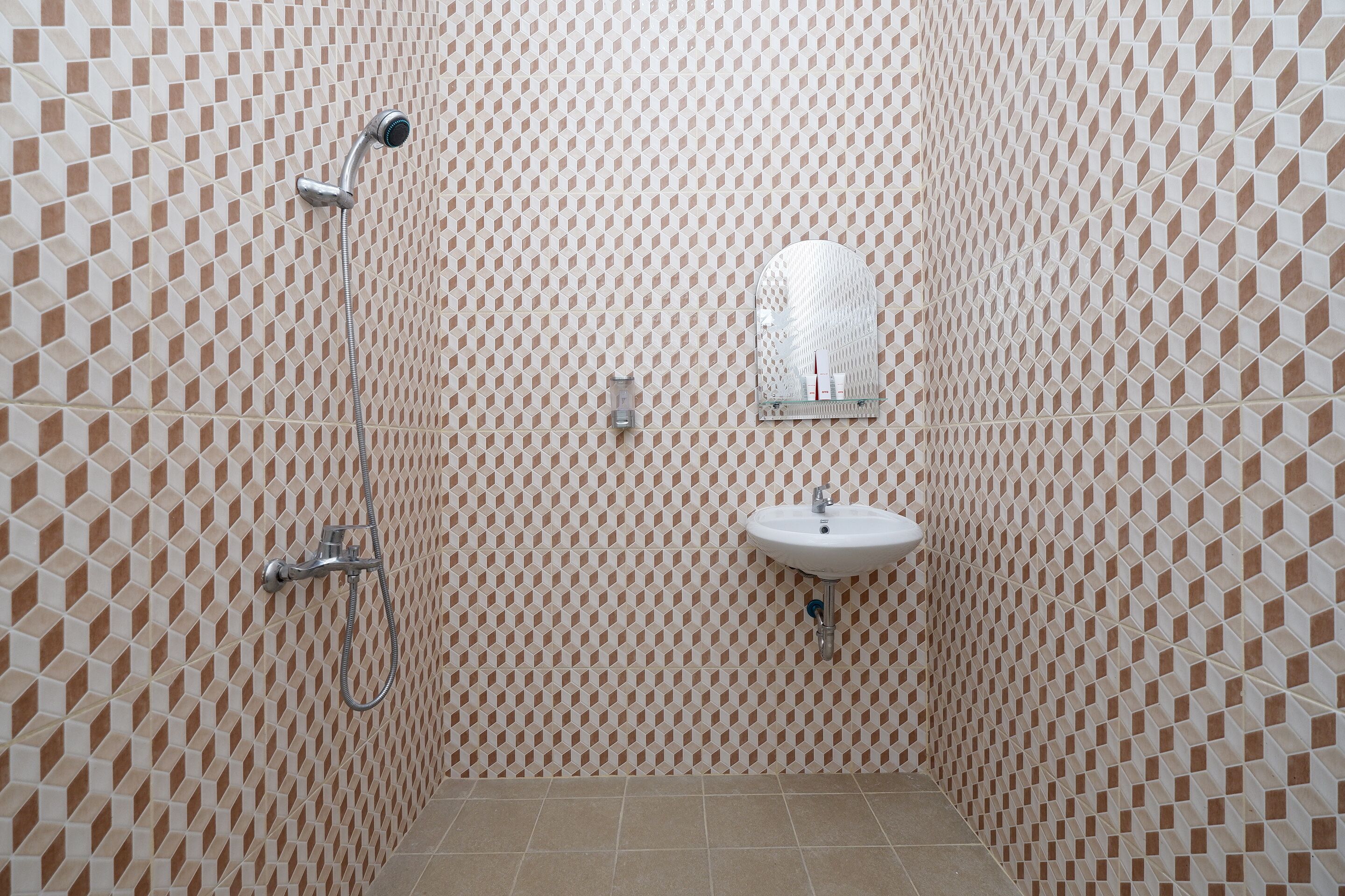 Ein Badezimmer mit Wandfliesen mit geometrischem Muster, einer Dusche und einem Waschbecken.