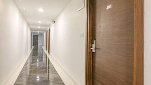 A hallway with a wooden door labeled "401" and a modern light fixture on the ceiling. - Collection O 30002 Bhel Hyderabad (Sangareddi)