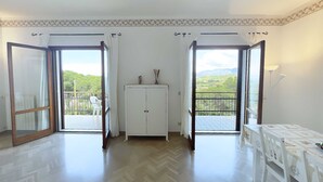 A room with a herringbone floor, a white cabinet, and a table with a nautical-themed tablecloth. - Villa Bel Panorama - a beautiful house with an amazing sea view (Portoferraio)