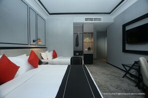 Una habitación de hotel con una cama grande, un escritorio, un televisor y un armario.