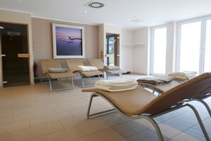 Une pièce avec des fauteuils inclinables, un tableau et une vue sur l’extérieur.