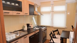 Une cuisine compacte équipée d’une cuisinière, d’un évier et d’un coin repas avec une table et des chaises.