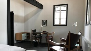 A hotel room with two beds, a desk, a chair, a radiator, and a window. - House of Finn Juhl Hotel Hakuba (Hakuba)