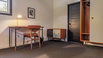 A compact room with a desk, chair, and a small cabinet.