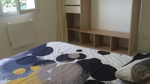 Ein Schlafzimmer mit einem Bett, einem Einbauschrank und einem Fenster.